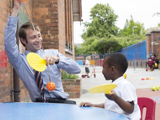 Teacher and pupil with table tennis rackets