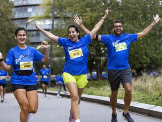 Runners smiling and waving at camera during Run the River 2023