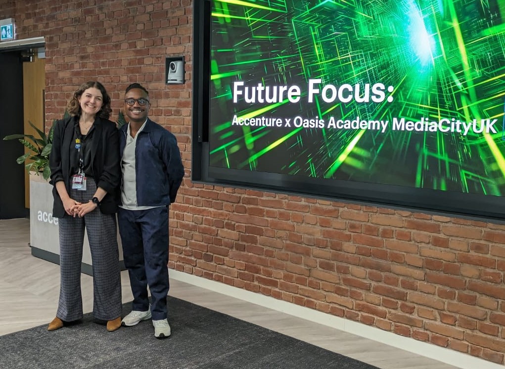 Lauren standing in front of a Future Focus display at Accenture x Oasis Academy MediaCityUK.
