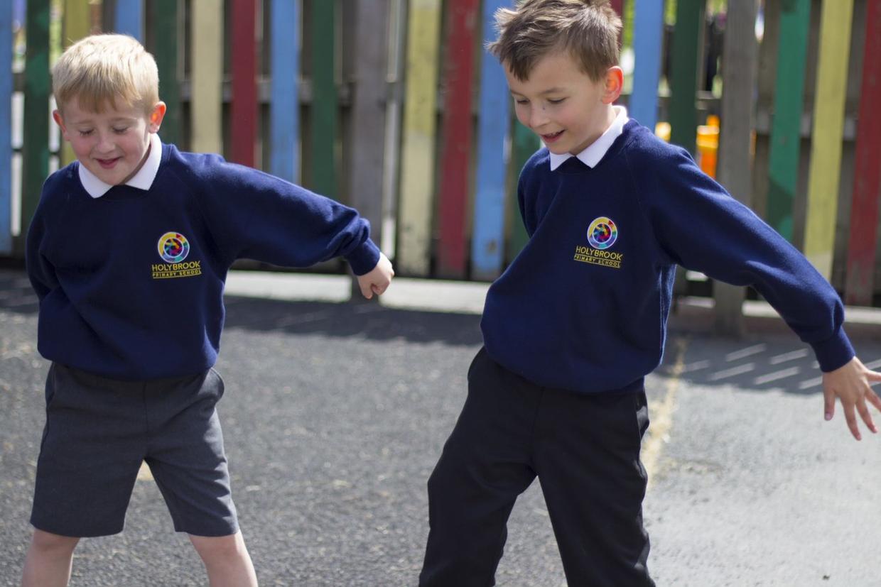 Two pupils kicking a ball