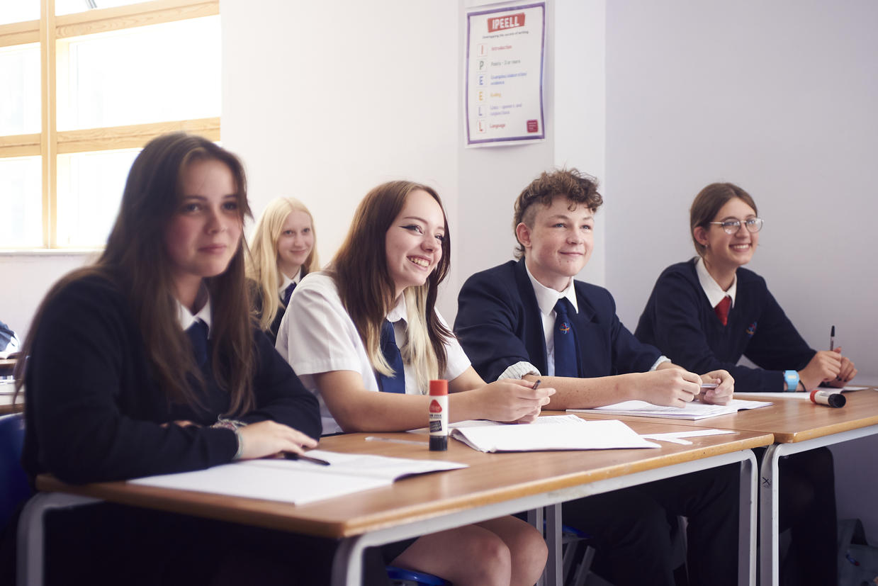 Five students sitting in their desks in a classroom