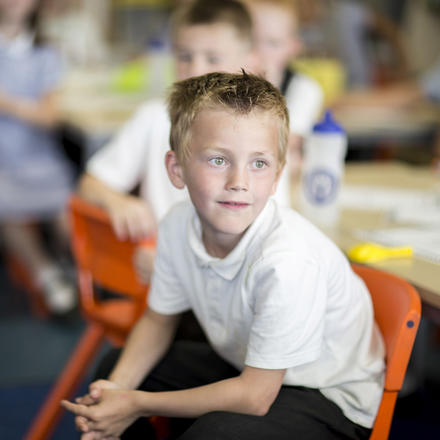 A pupil sits on an orange chair