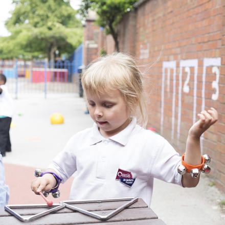 A pupil plays with musical instruments