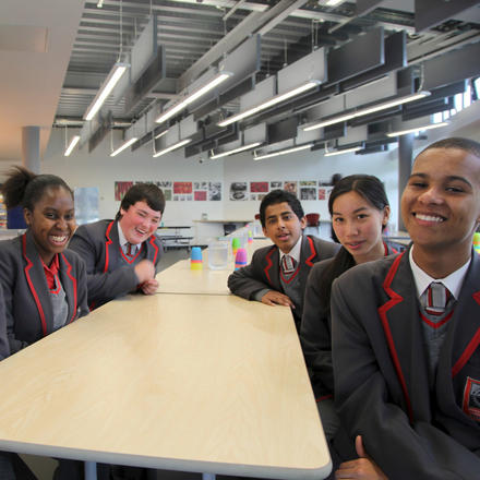 Pupils laugh while sitting a t a table