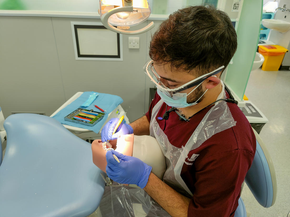 Image of Umair practicing dental work on a test dummy