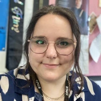 Teacher wearing glasses smiling at camera