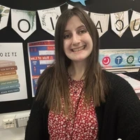 Jodie-Lee, a Teach First trainee RE teacher, smiling in her classroom.