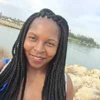 Abigail smiling outdoors beside a lake.