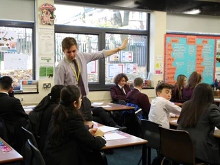 Teacher standing in a classroom talking to students