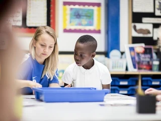Pupil and teacher interacting in the classroom.