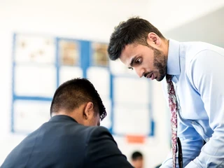 a teacher helps a pupil with his work