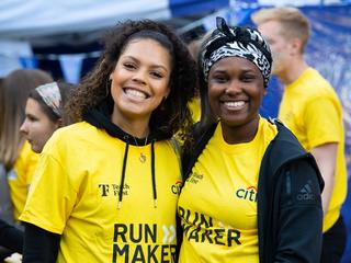 Two people in yellow running shirts smiling