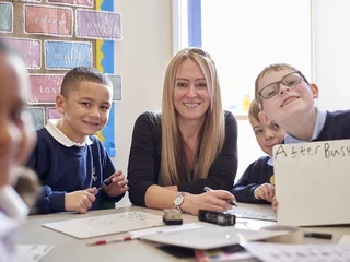 Female teacher with her students smiling at camera
