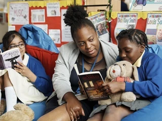 Female teacher reading together with her students