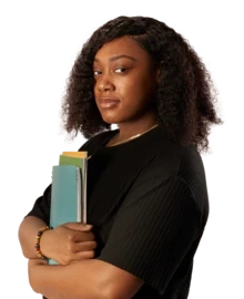 A woman looking to camera while holding a stack of exercise books..