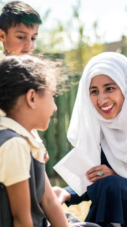 Female BAME teacher with students outside