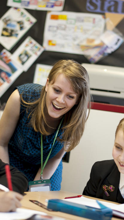 A teacher helps pupils with their work