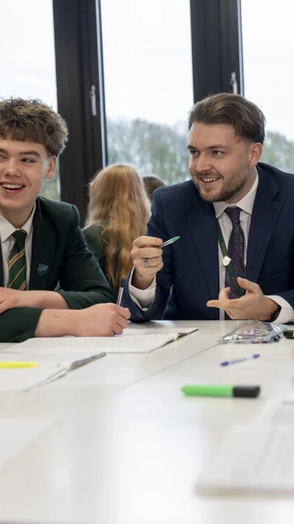 Teacher engaging secondary school students in a collaborative classroom discussion.