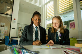 Young people in school working together on an exercise book