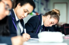 Secondary school students writing in class.