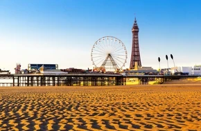 Blackpool seafront with sandy beach, Central Pier, Ferris wheel and Blackpool Tower in the background.