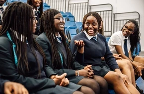 Secondary students chatting and smiling together.